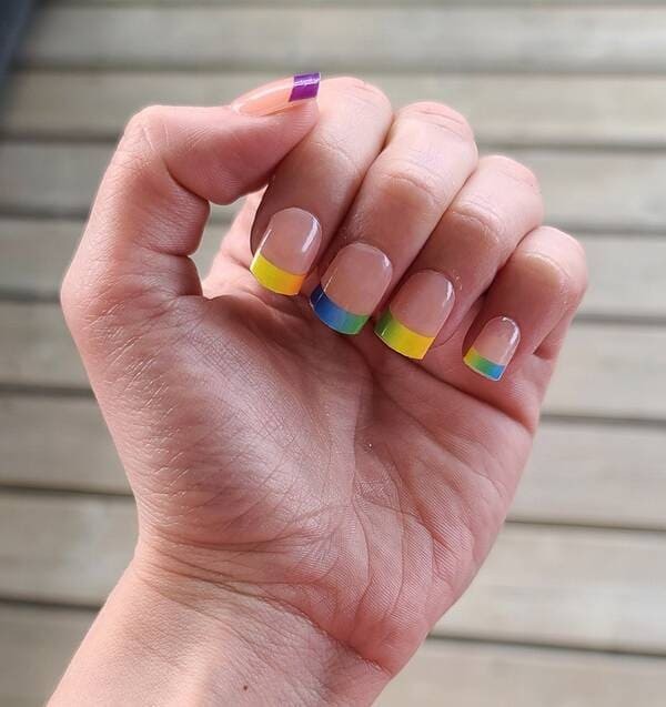 Rainbow gradient french manicure with clear top.