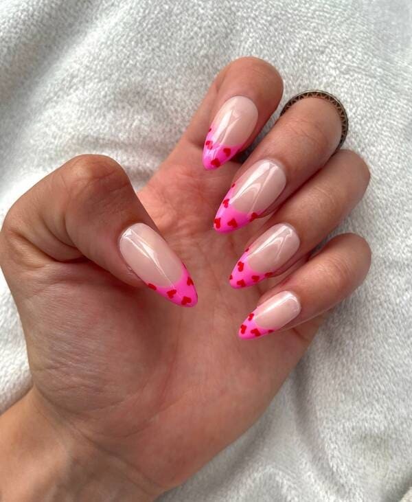 Pink hearts french tip nails.