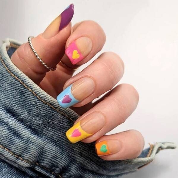 Rainbow french tips with hearts nails.