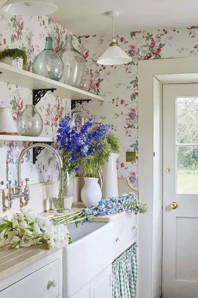 Consider a British kitchen with patterned wallpaper paired with curtain coverings.