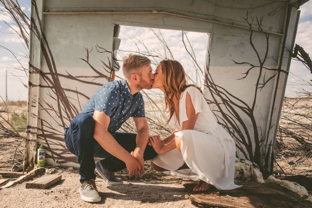 The couple snuck a kiss in a little shanty by the sea for their engagement photo shoot. That just screams artistic engagement photos!