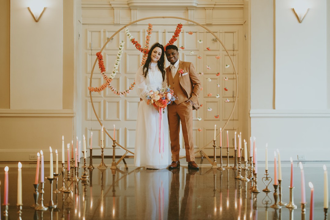 This floral circle arch plus candlelit aisle make a simple, 70s-inspired statement for a spring wedding.