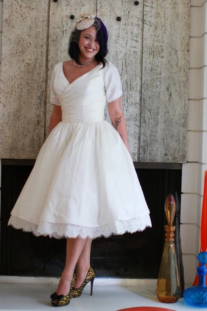 Retro tea-length wedding dress with full back coverage but only moderate shoulder coverage