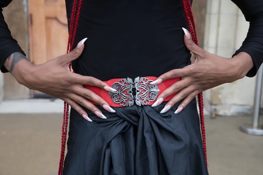 Those stiletto nails! That ornate red belt!