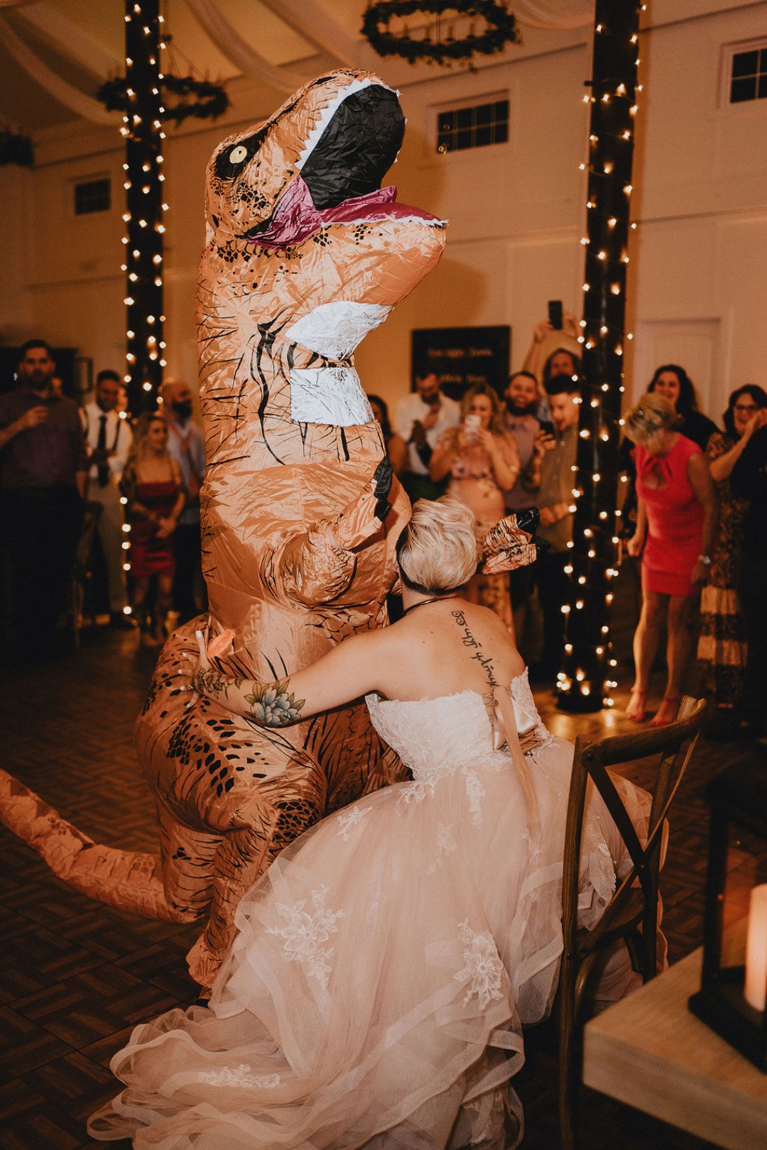 But wait! It seems like the bride is…motorboating the dinosaur?