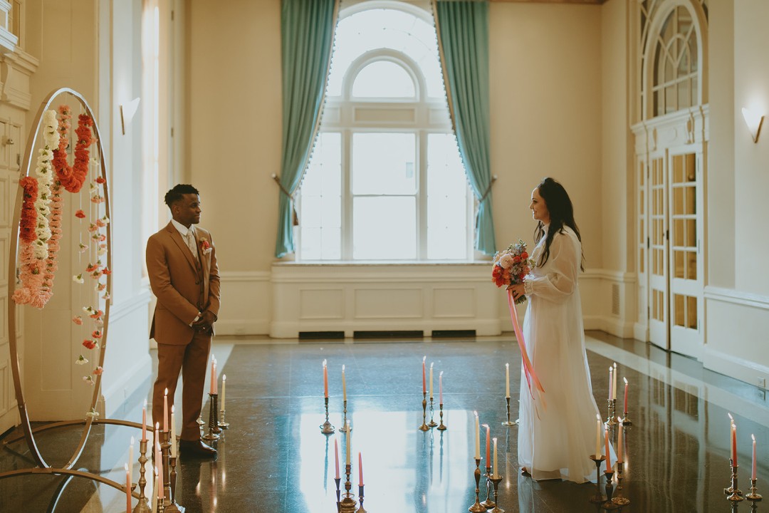 This floral circle arch plus candlelit aisle make a simple, 70s-inspired statement for a spring wedding.