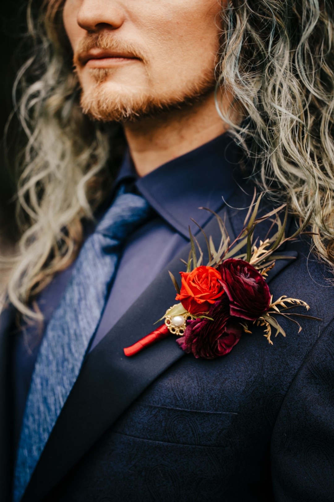 Each member of the triad got their own unique blood-red rose boutonniere.